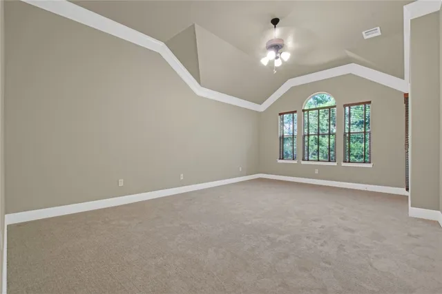 en empty room with windows and ceiling fan