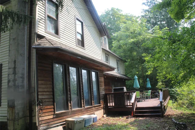 a view of a house with a deck and backyard