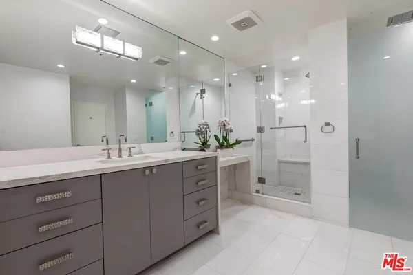 a bathroom with a granite countertop sink mirror and shower