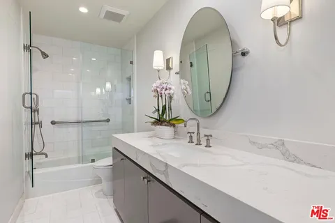 a bathroom with a double vanity sink mirror and bathtub