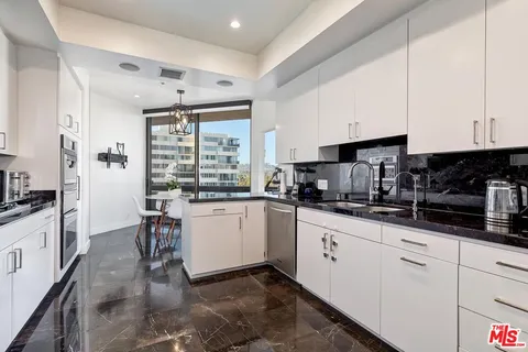 a kitchen with granite countertop white cabinets and white appliances