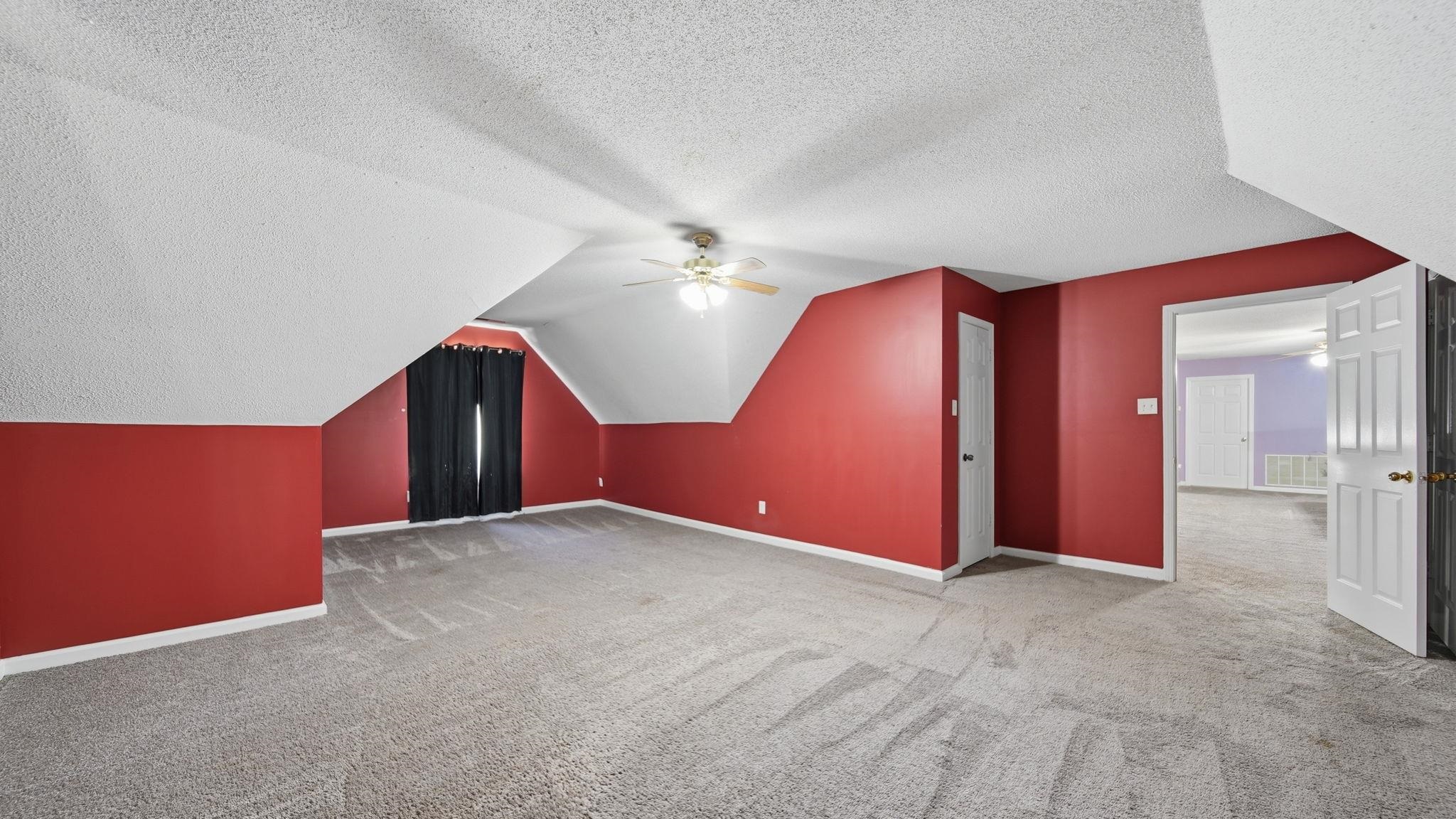 217 Rae Drive Munford, TN 38058 - Photo 32 of 40 Spacious room featuring sloped ceilings, textured carpeting, and a ceiling fan. Walk in closet. Upstairs.