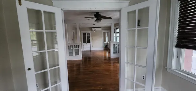 a view of a hallway with wooden floor and staircase