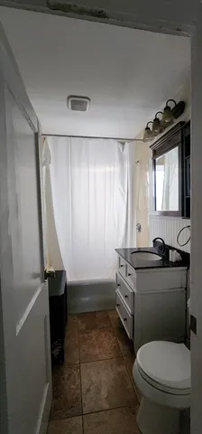 a bathroom with a granite countertop toilet a sink and a mirror