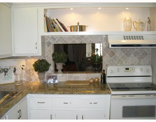a kitchen with stainless steel appliances granite countertop a stove and a white cabinets