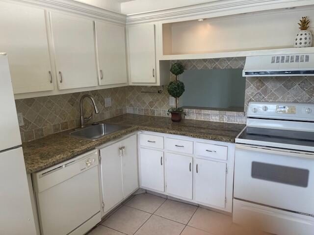 2901 Fiore Way, Unit 103 Delray Beach, FL 33445 - Photo 6 of 29 a kitchen with granite countertop white cabinets and white appliances