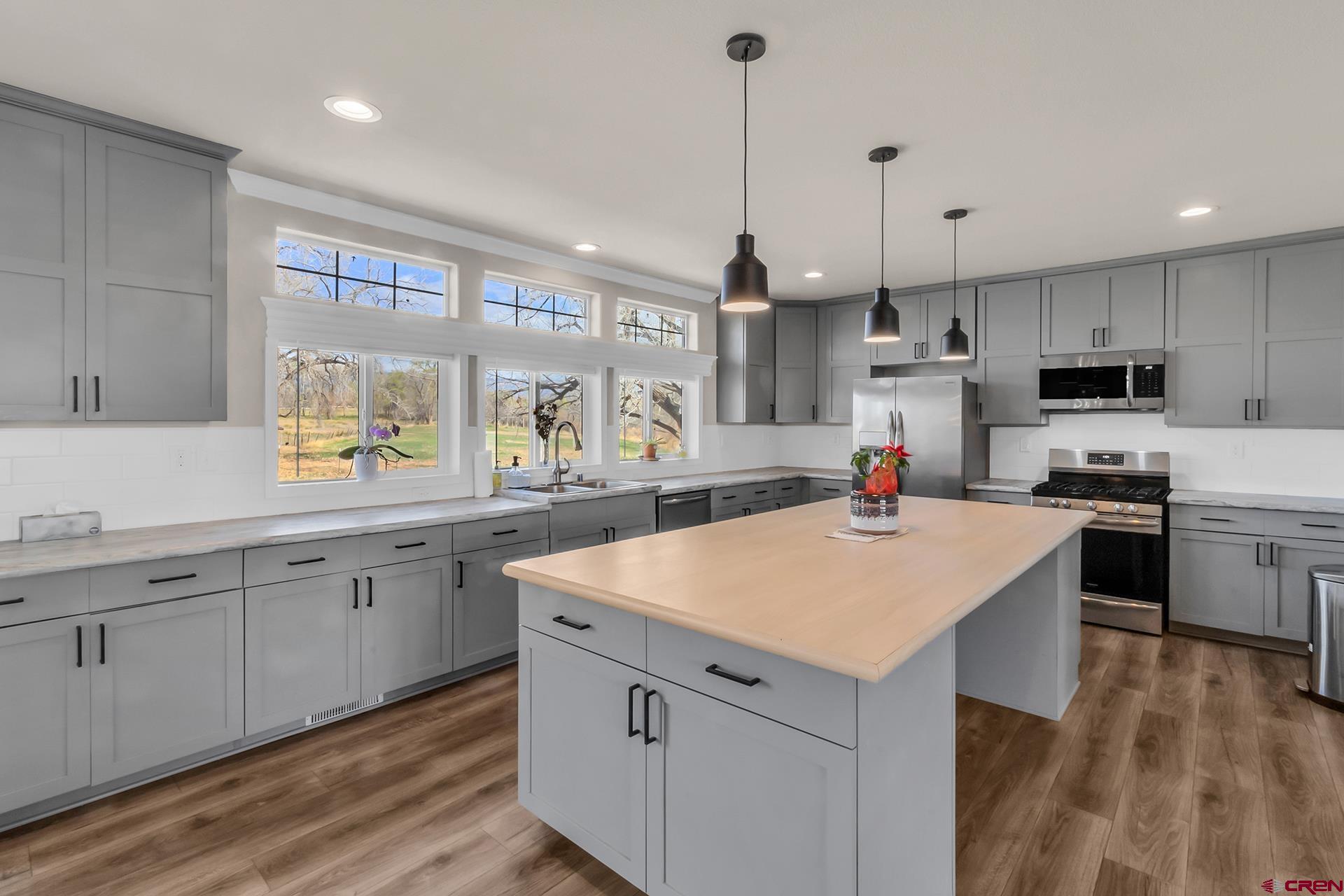 21357 Knight Road Austin, CO 81410 - Photo 12 of 35 a kitchen with a sink a stove a center island a counter space and a window