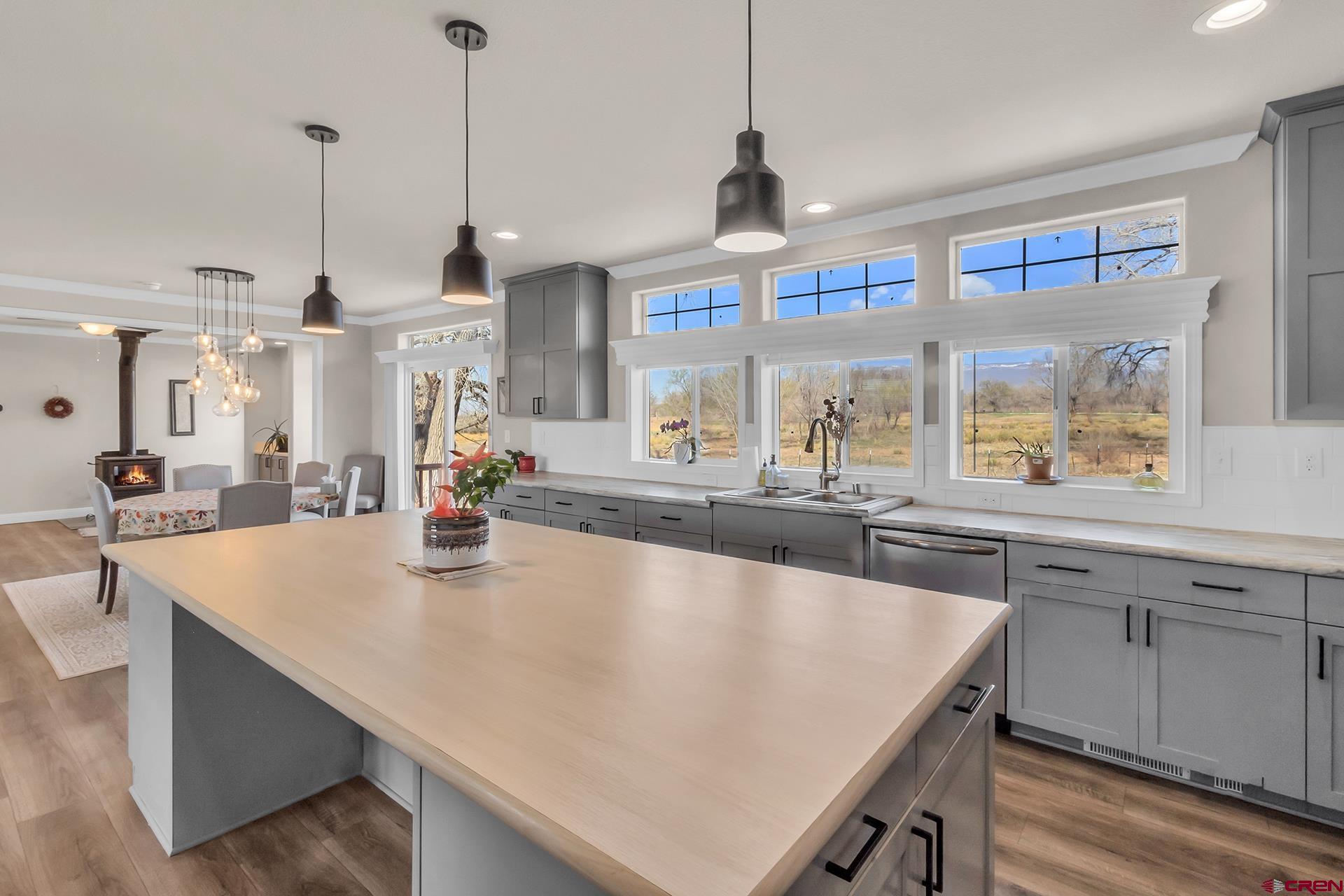21357 Knight Road Austin, CO 81410 - Photo 13 of 35 a kitchen with stainless steel appliances a sink a center island and a wooden floors