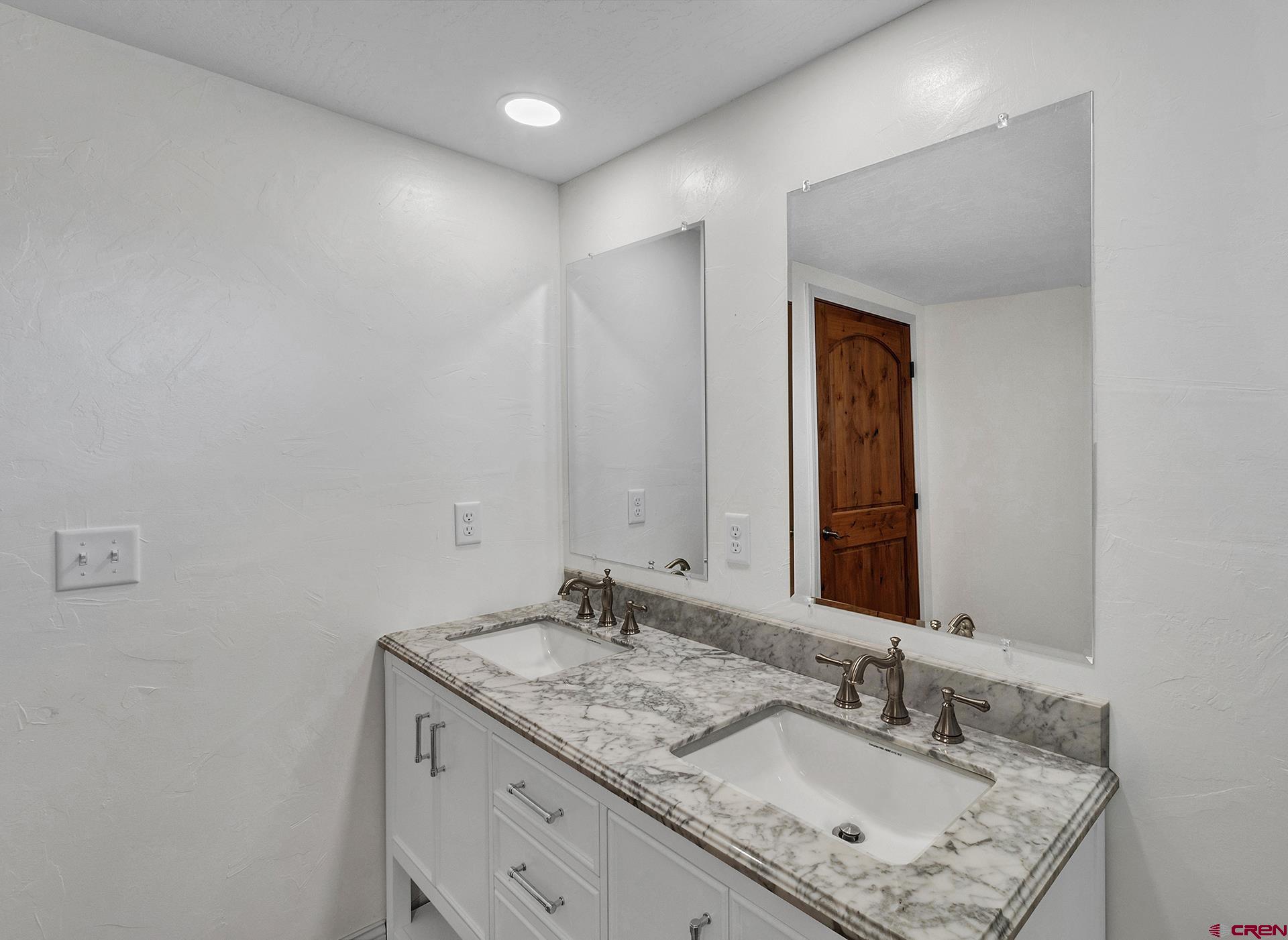 21357 Knight Road Austin, CO 81410 - Photo 31 of 35 a bathroom with a granite countertop sink and a mirror