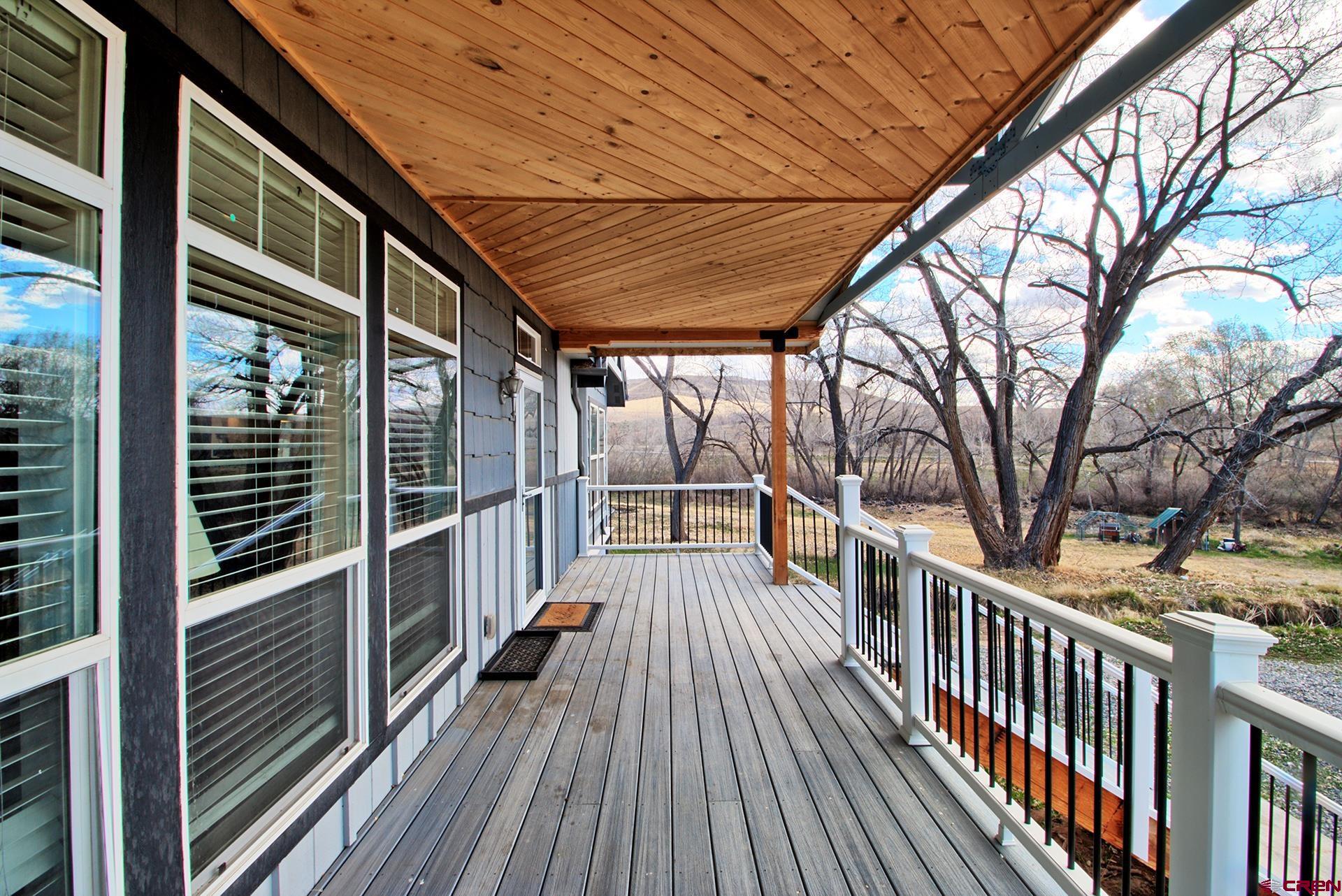 21357 Knight Road Austin, CO 81410 - Photo 9 of 35 a view of balcony with wooden floor and fence and a floor to ceiling window
