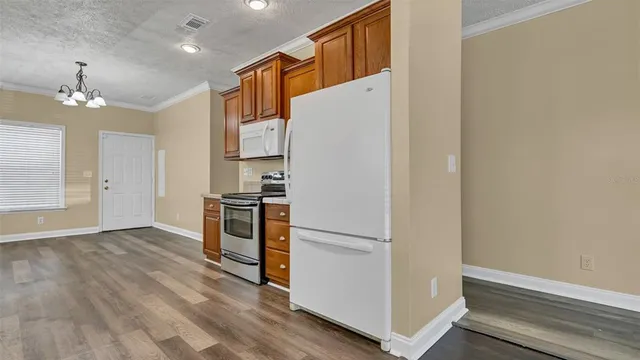 a view of kitchen with wooden floor and electronic appliances