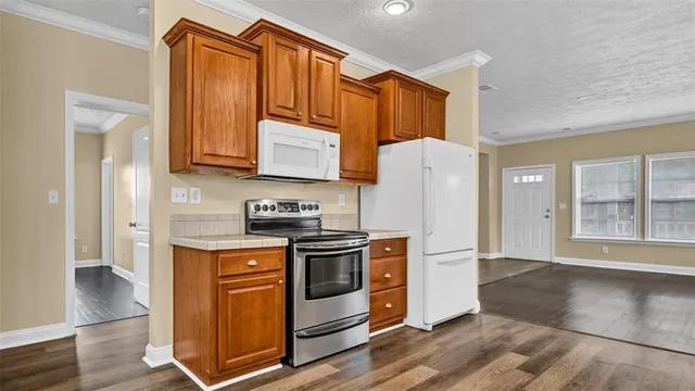 a kitchen with stainless steel appliances granite countertop a stove a refrigerator and a cabinets
