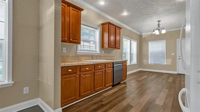 a kitchen with stainless steel appliances granite countertop a sink and wooden cabinets