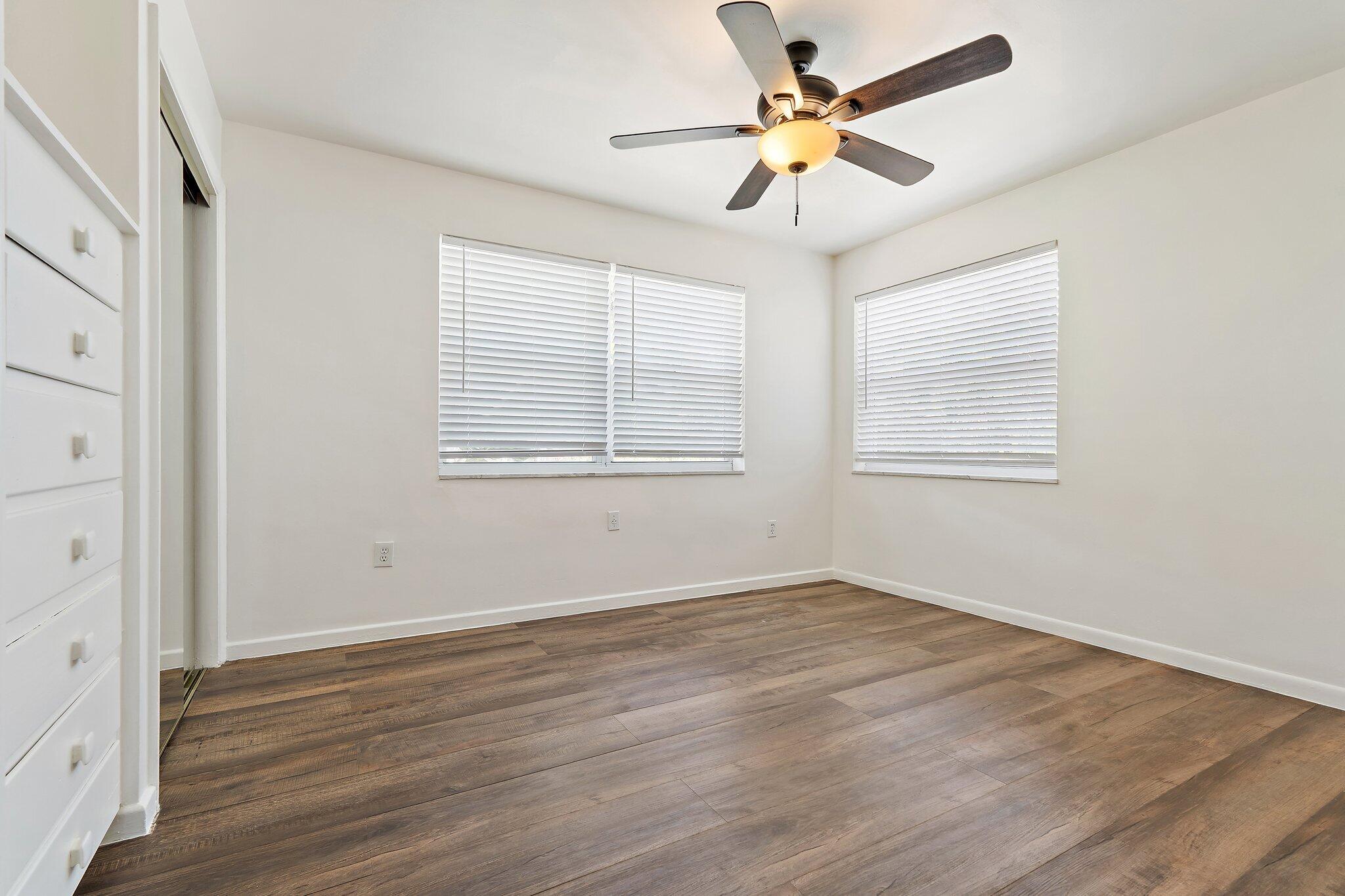 19147 Southeast Hillcrest Drive, Unit A Jupiter, FL 33469 - Photo 11 of 17 a view of an empty room with wooden floor and a window