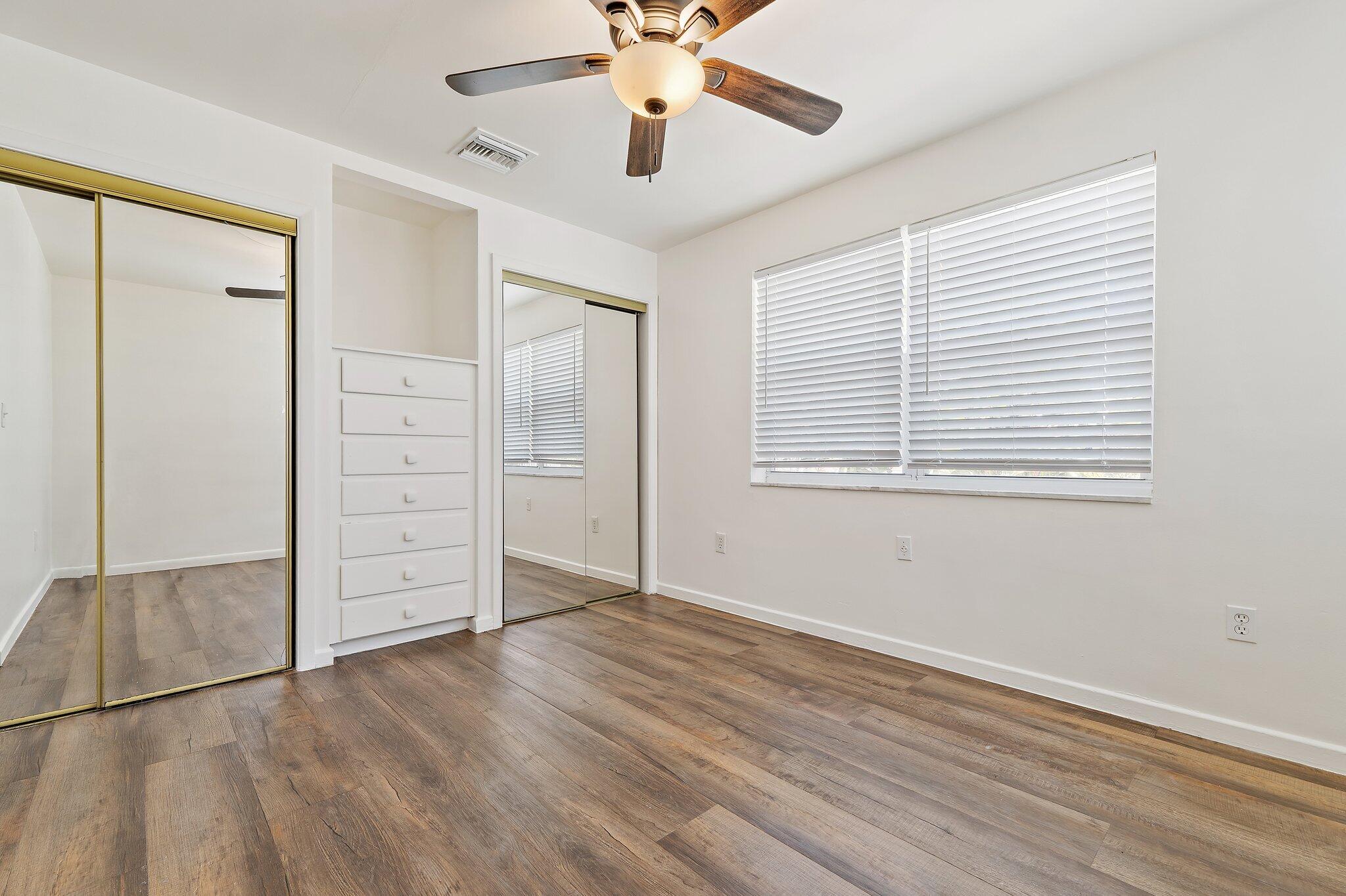 19147 Southeast Hillcrest Drive, Unit A Jupiter, FL 33469 - Photo 12 of 17 wooden floor in an empty room with a window