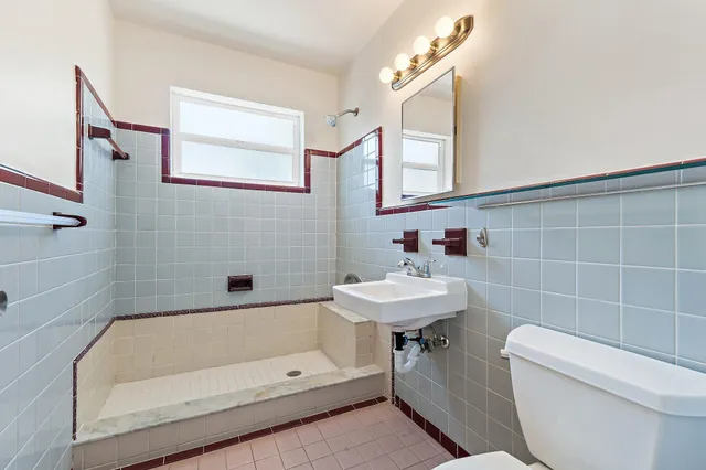 a bathroom with a sink a toilet and shower