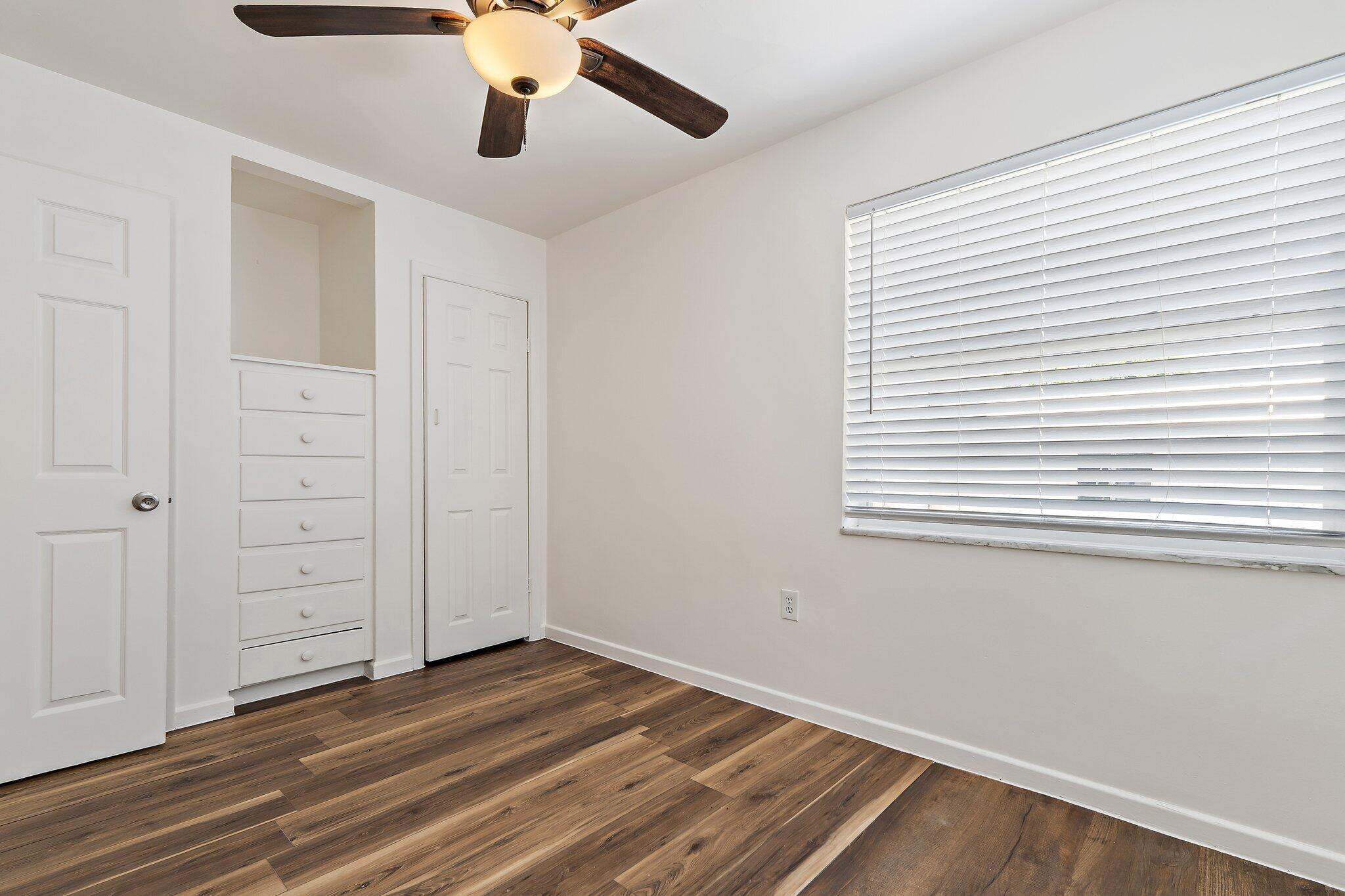19147 Southeast Hillcrest Drive, Unit A Jupiter, FL 33469 - Photo 16 of 17 wooden floor in an empty room with a window