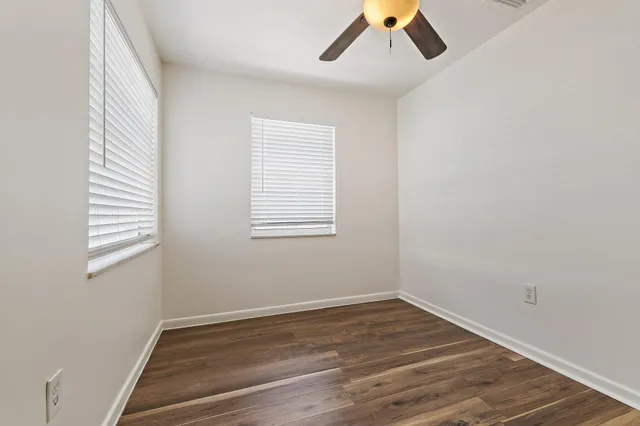 an empty room with a window and wooden floor