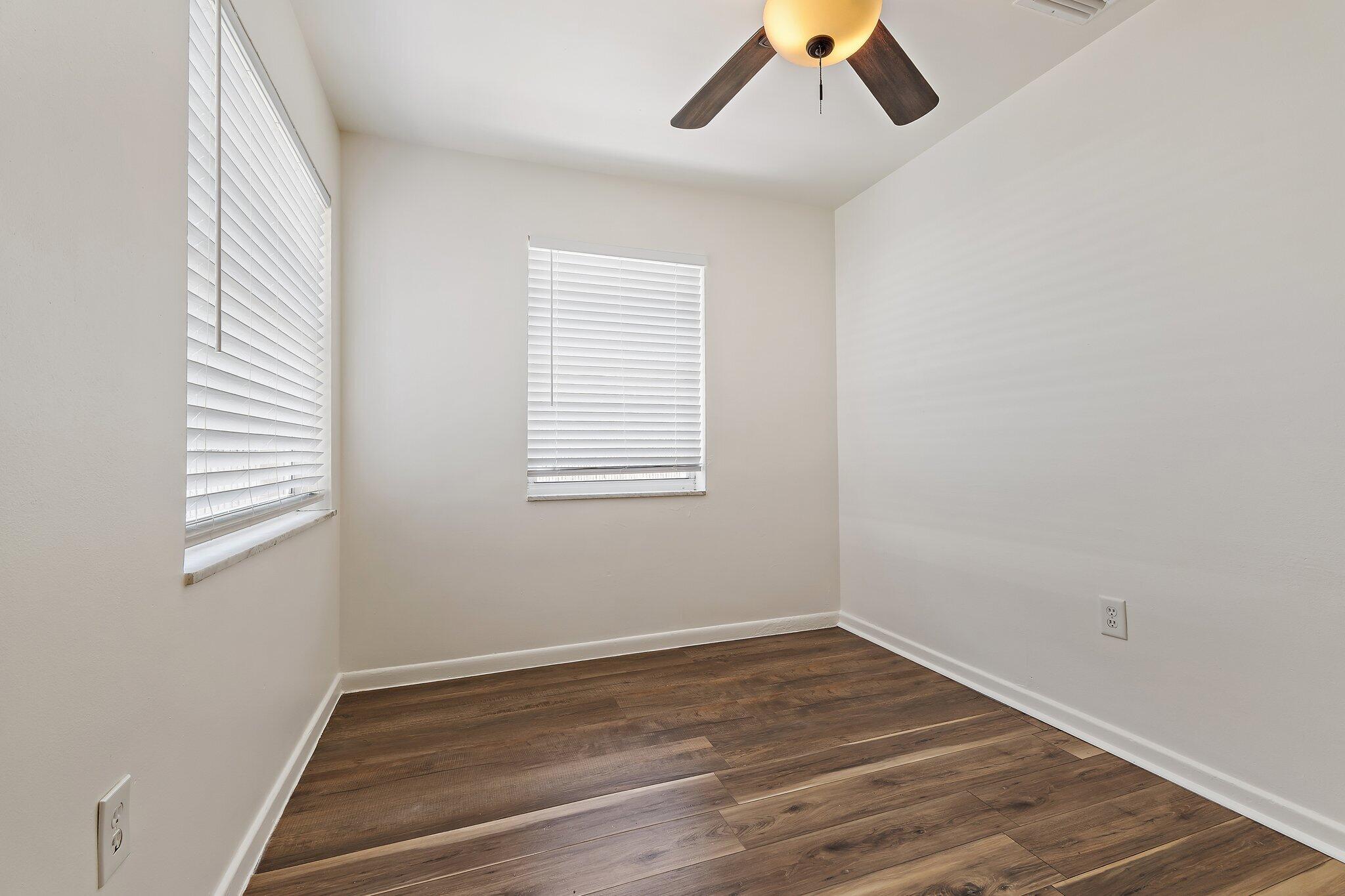 19147 Southeast Hillcrest Drive, Unit A Jupiter, FL 33469 - Photo 17 of 17 an empty room with a window and wooden floor