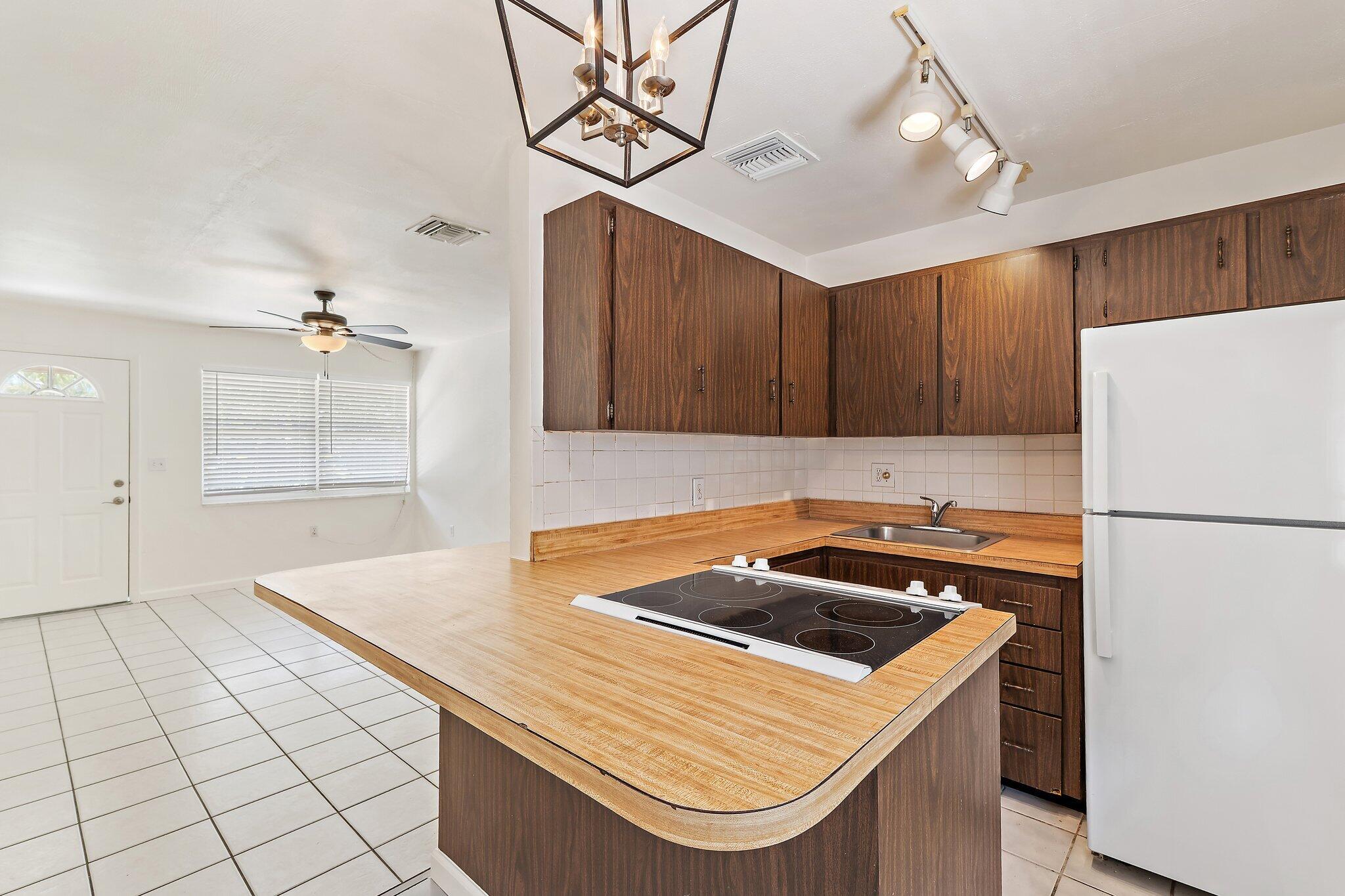 19147 Southeast Hillcrest Drive, Unit A Jupiter, FL 33469 - Photo 8 of 17 a kitchen with a appliances a sink and cabinets