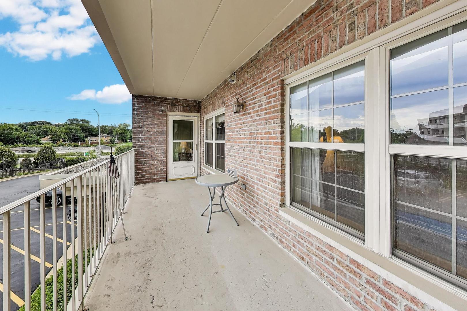 1200 South Prospect Avenue, Unit 108 Elmhurst, IL 60126 - Photo 8 of 19 a porch with a bench next to a yard