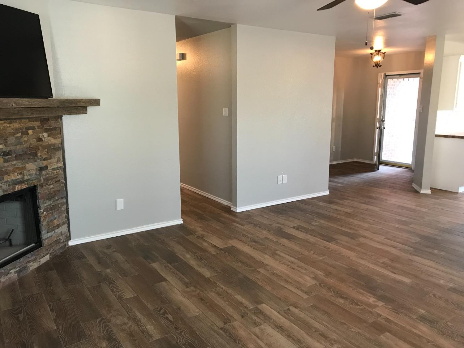 6201 5th Street Lubbock, TX 79416 - Photo 13 of 32 an empty room with wooden floor fireplace and windows