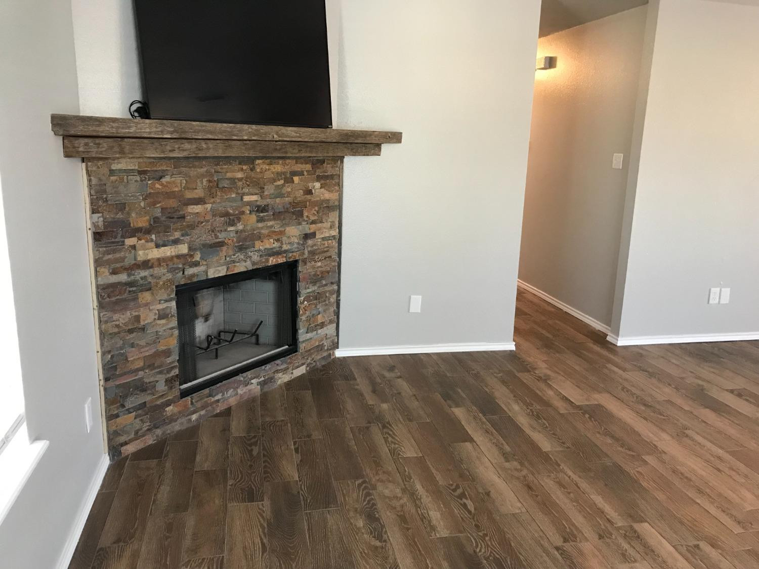 6201 5th Street Lubbock, TX 79416 - Photo 15 of 32 a view of empty room with wooden floor and fireplace