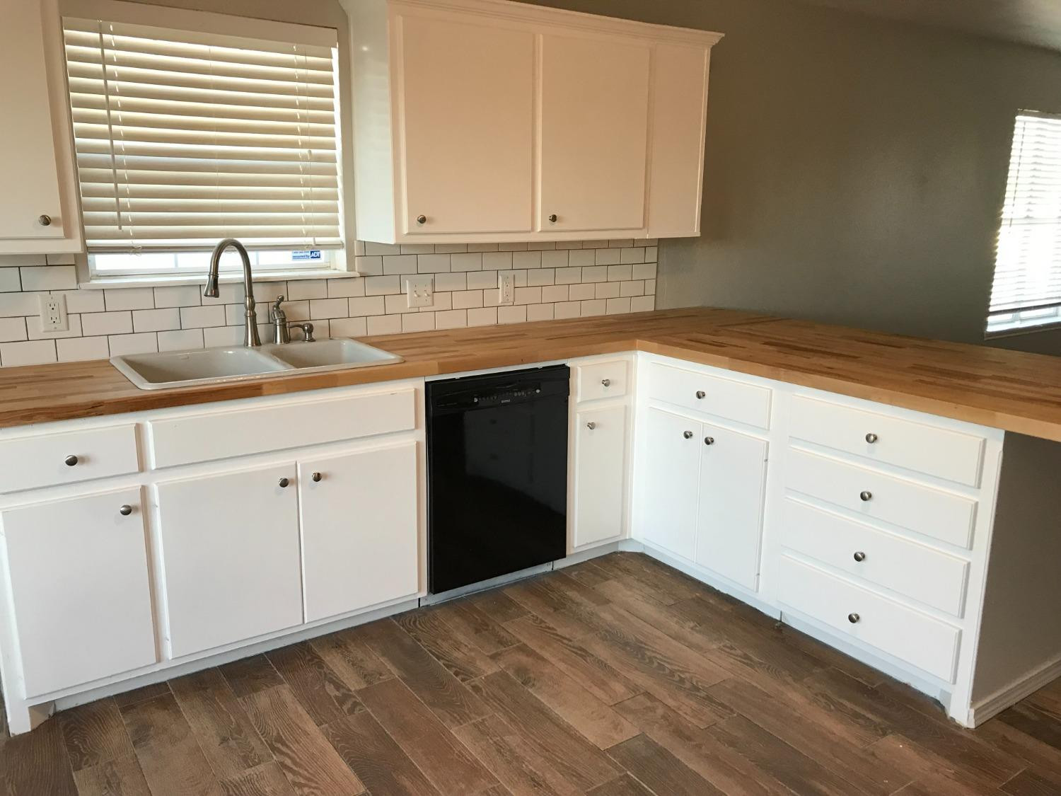 6201 5th Street Lubbock, TX 79416 - Photo 2 of 32 a kitchen with granite countertop white cabinets and sink