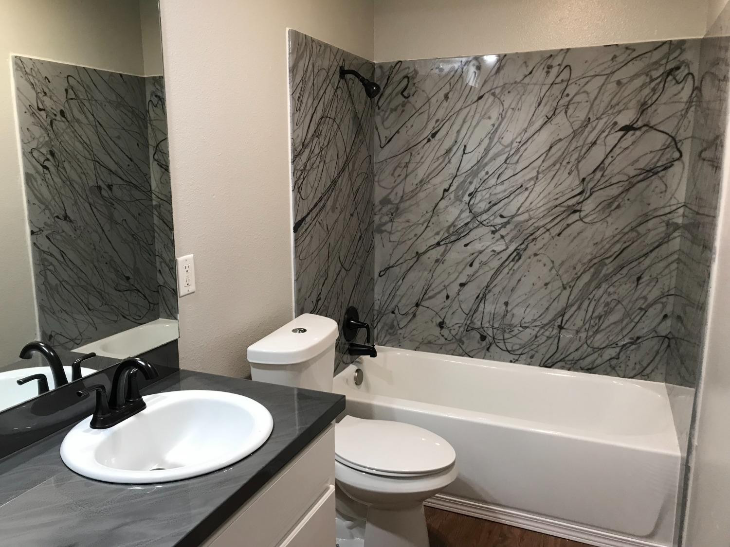 6201 5th Street Lubbock, TX 79416 - Photo 27 of 32 a bathroom with a sink a toilet and bathtub