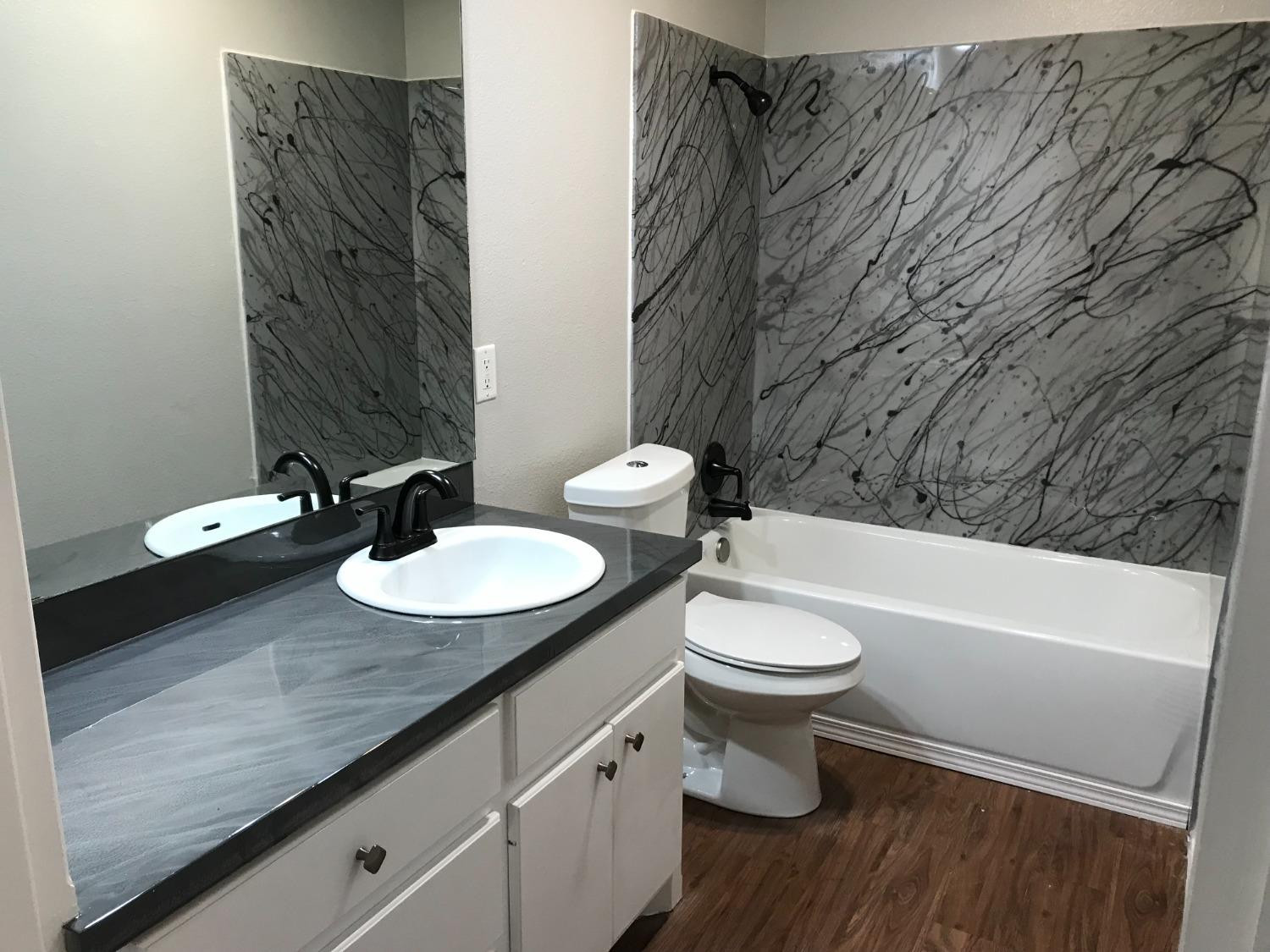 6201 5th Street Lubbock, TX 79416 - Photo 28 of 32 a bathroom with a toilet a sink and a bathtub
