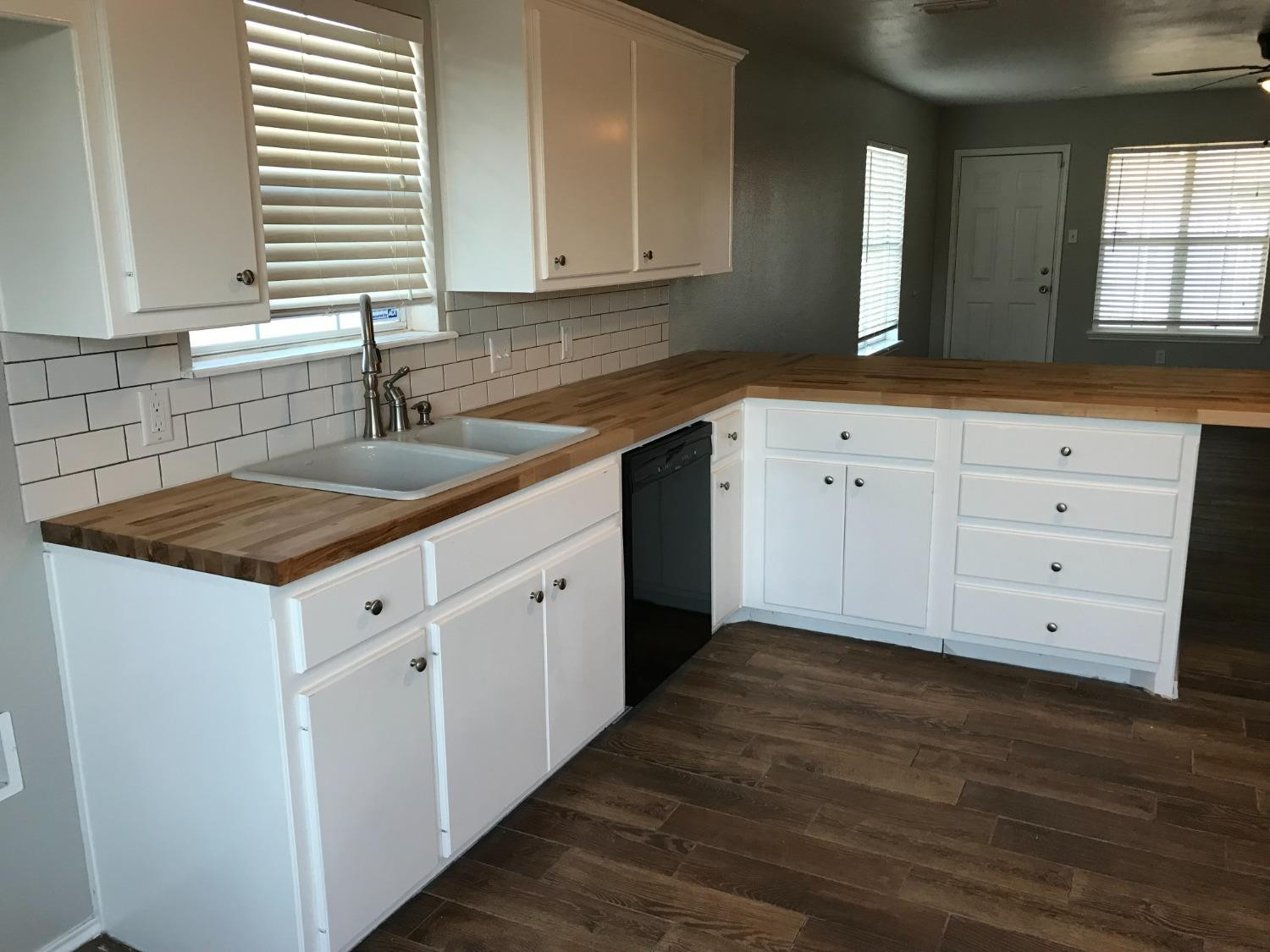 6201 5th Street Lubbock, TX 79416 - Photo 4 of 32 a kitchen with granite countertop white cabinets and a sink