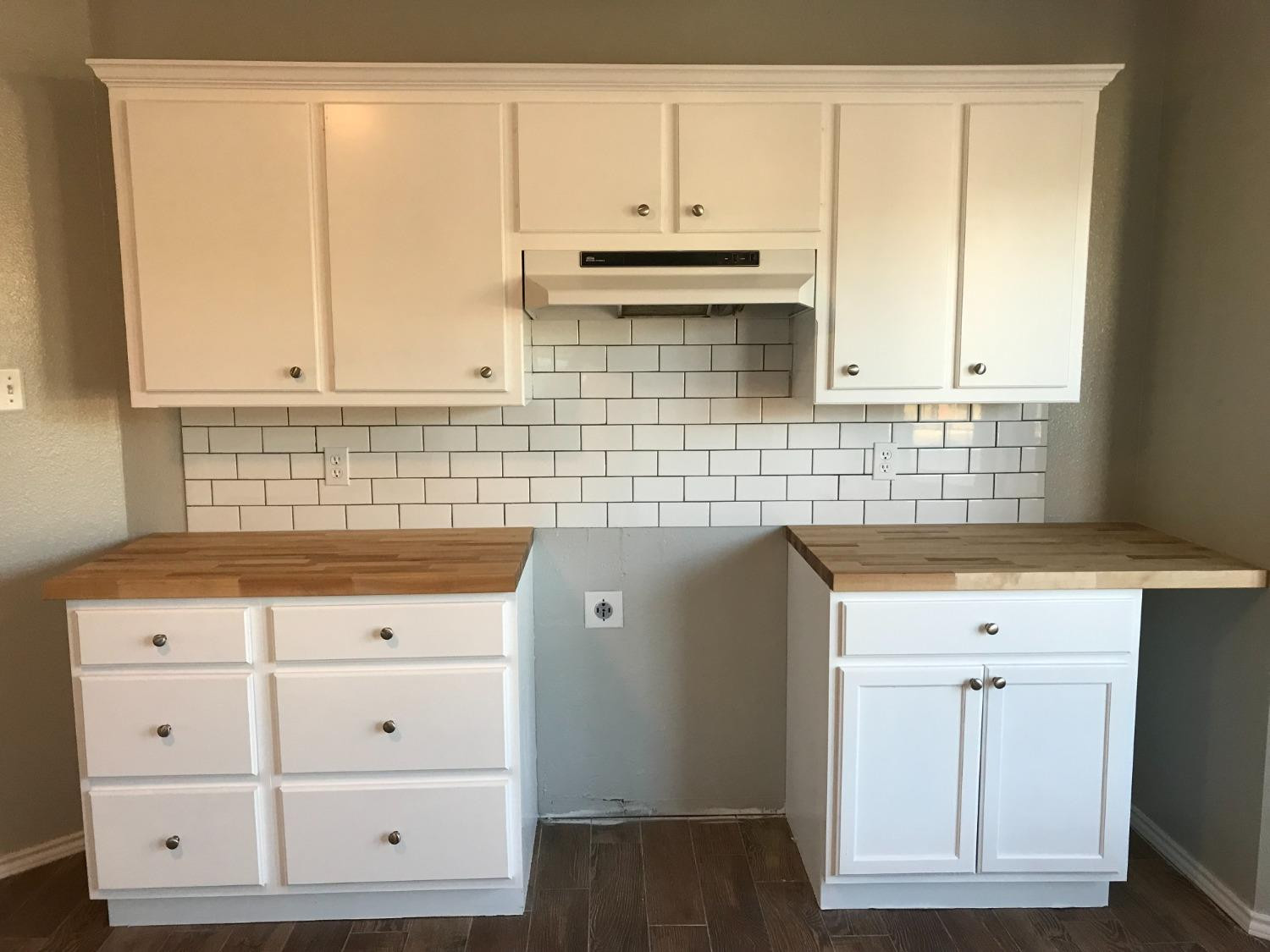 6201 5th Street Lubbock, TX 79416 - Photo 6 of 32 a view of kitchen with granite countertop white cabinets and a wooden floor