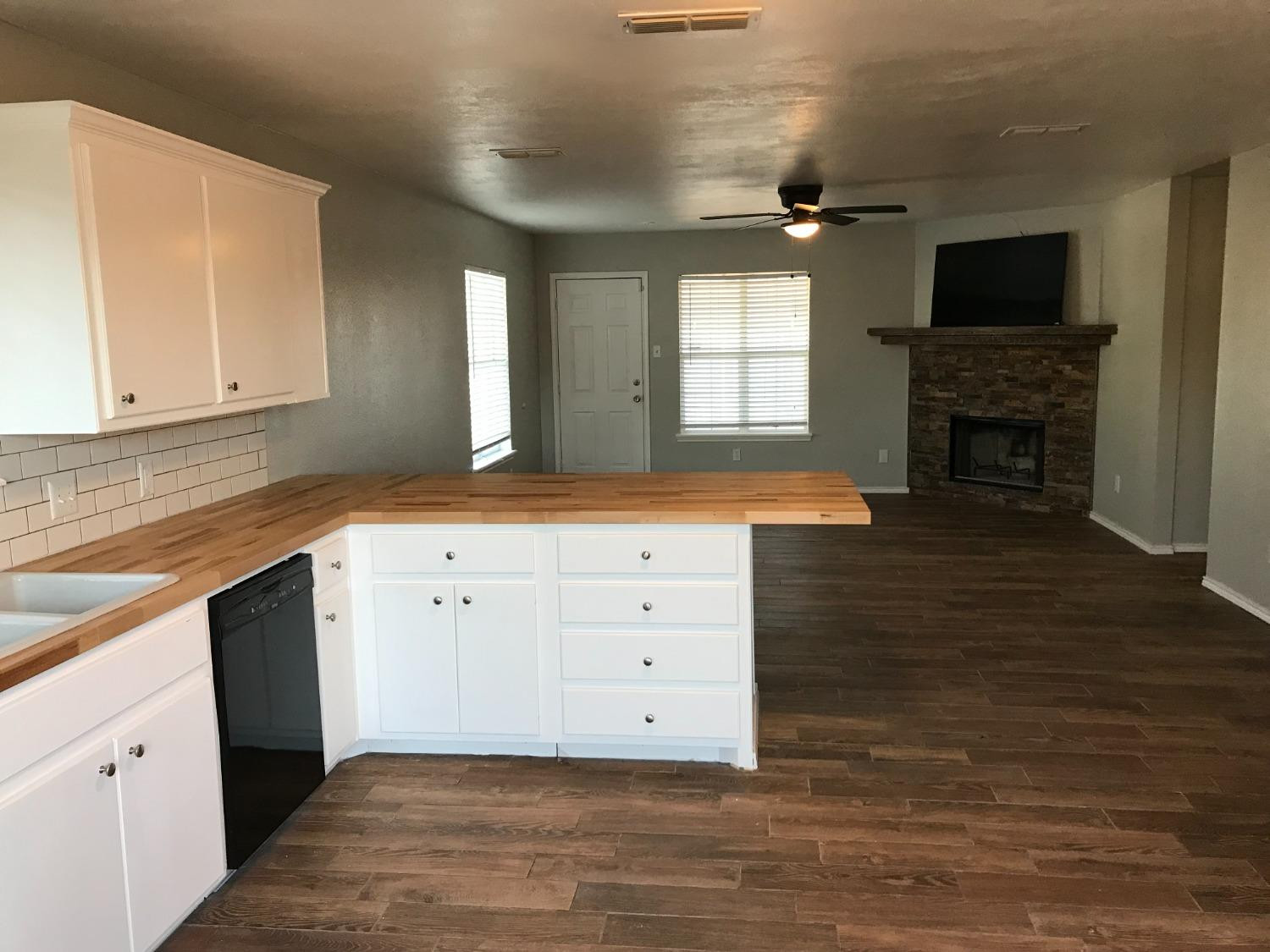 6201 5th Street Lubbock, TX 79416 - Photo 9 of 32 a kitchen with a sink and a fireplace