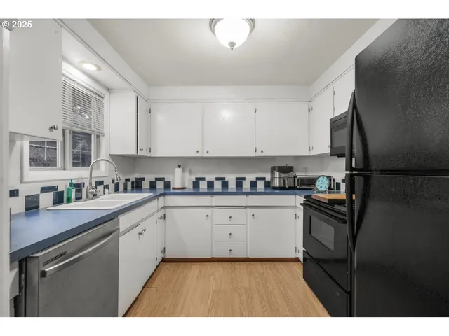 a kitchen with granite countertop white cabinets and white appliances