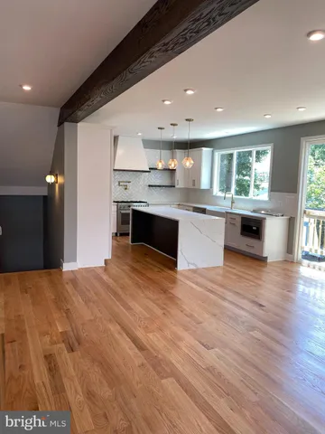 a kitchen with stainless steel appliances granite countertop a sink cabinets and wooden floor