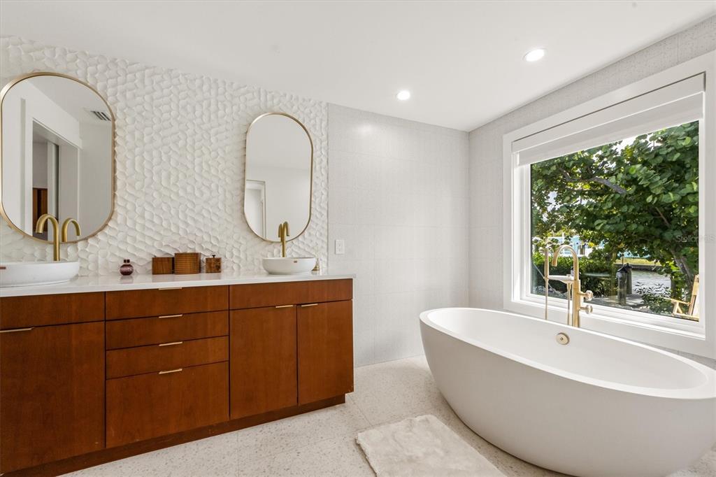 505 65th Street Holmes Beach, FL 34217 - Photo 23 of 64 a spacious bathroom with a double vanity sink a mirror and a bathtub