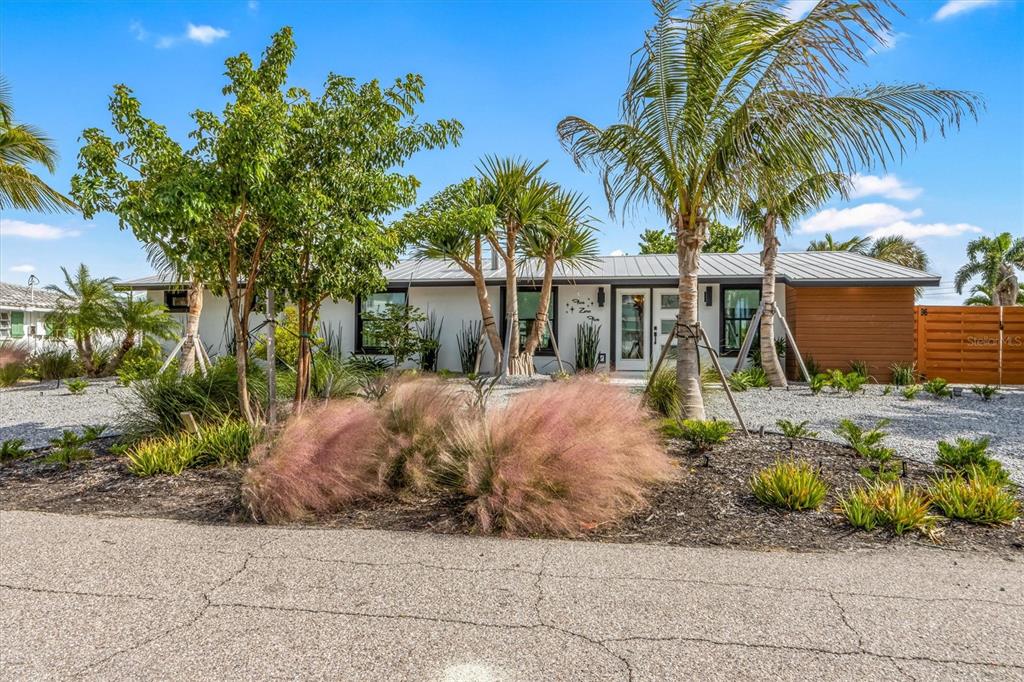 505 65th Street Holmes Beach, FL 34217 - Photo 3 of 64 a front view of house with yard and trees around