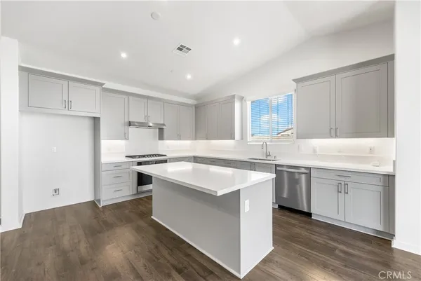 a kitchen with white cabinets appliances and sink