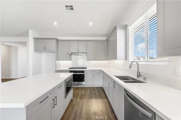 a kitchen with stainless steel appliances a sink stove and cabinets