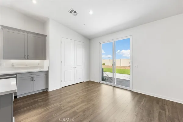 a view of an empty room with window and wooden floor