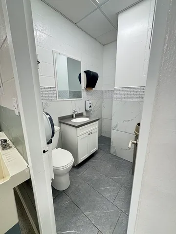 a bathroom with a toilet sink and mirror