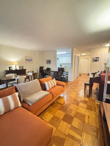a living room with furniture and a dining table with kitchen view