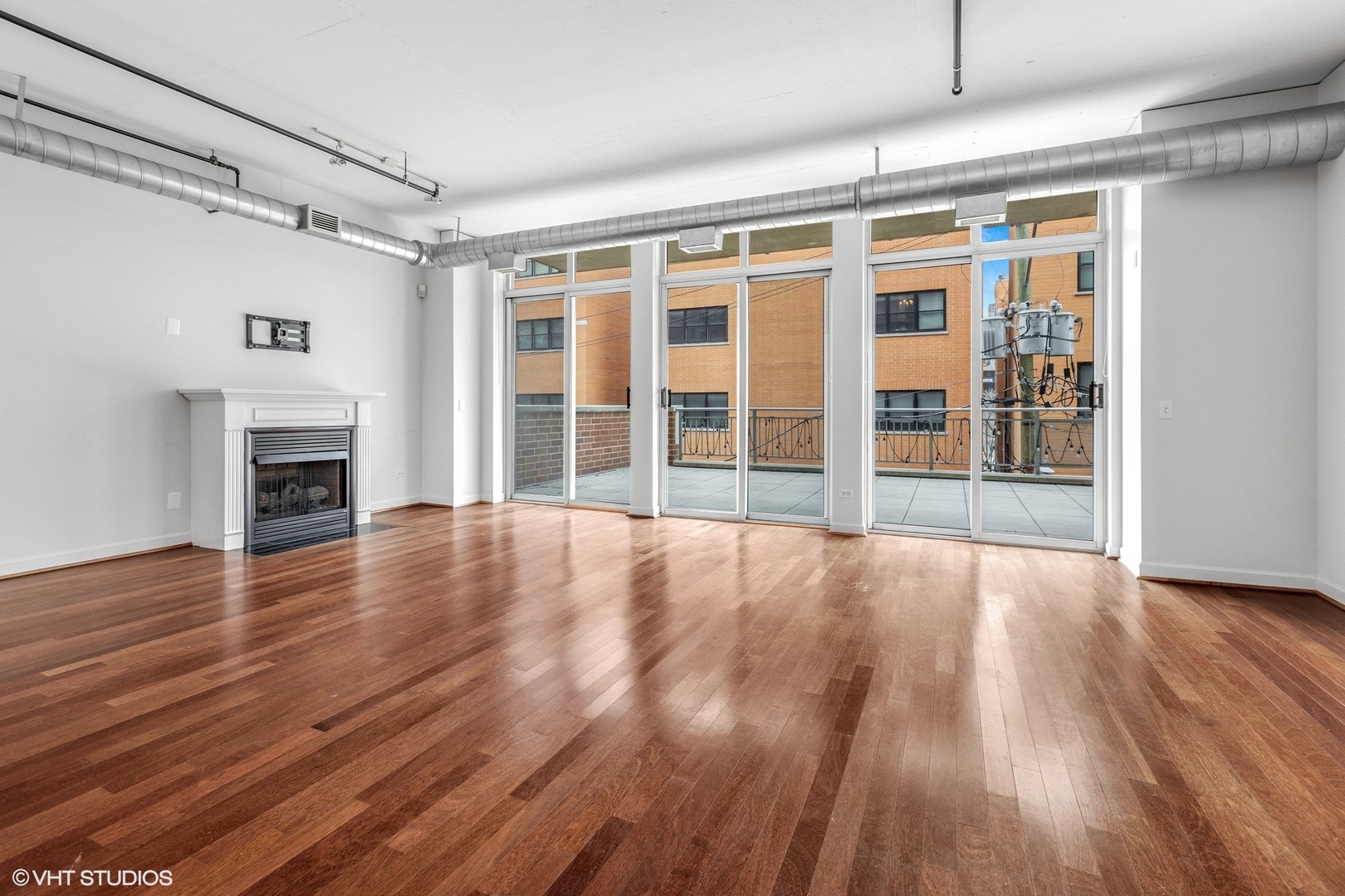 111 South Morgan Street, Unit 325 Chicago, IL 60607 - Photo 3 of 18 a view of empty room with wooden floor and fireplace