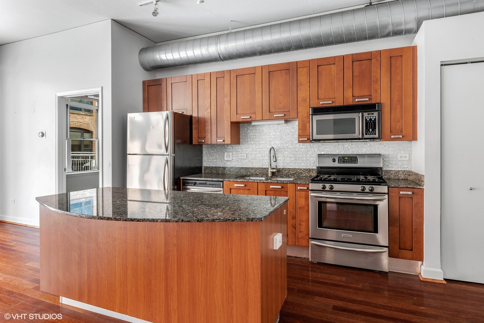 111 South Morgan Street, Unit 325 Chicago, IL 60607 - Photo 7 of 18 a kitchen with stainless steel appliances granite countertop a stove a refrigerator and a microwave