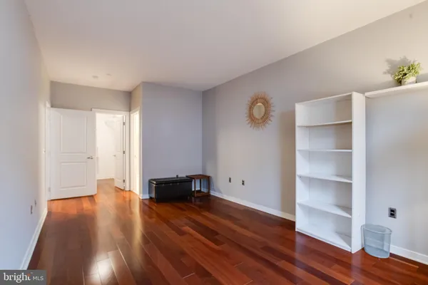 a view of empty room with wooden floor and window