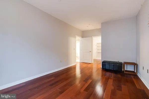a view of empty room with wooden floor