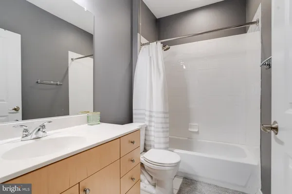 a bathroom with a double vanity sink toilet mirror and shower