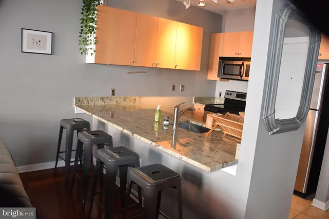a view of kitchen island with stainless steel appliances refrigerator stove microwave and furniture