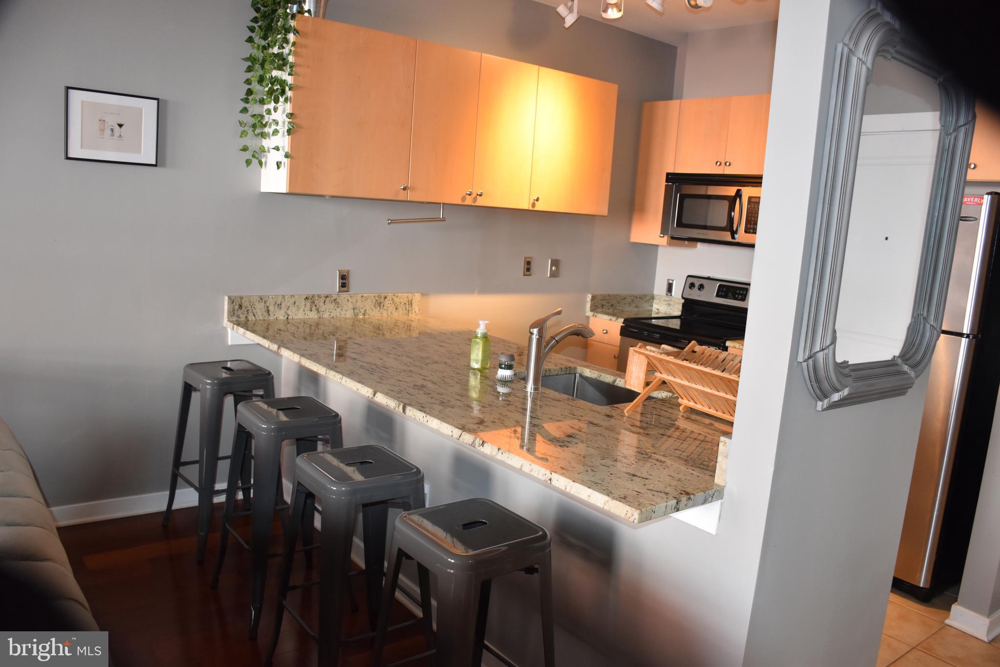 2007 Clipper Park Road, Unit 212 Baltimore, MD 21211 - Photo 8 of 33 a view of kitchen island with stainless steel appliances refrigerator stove microwave and furniture