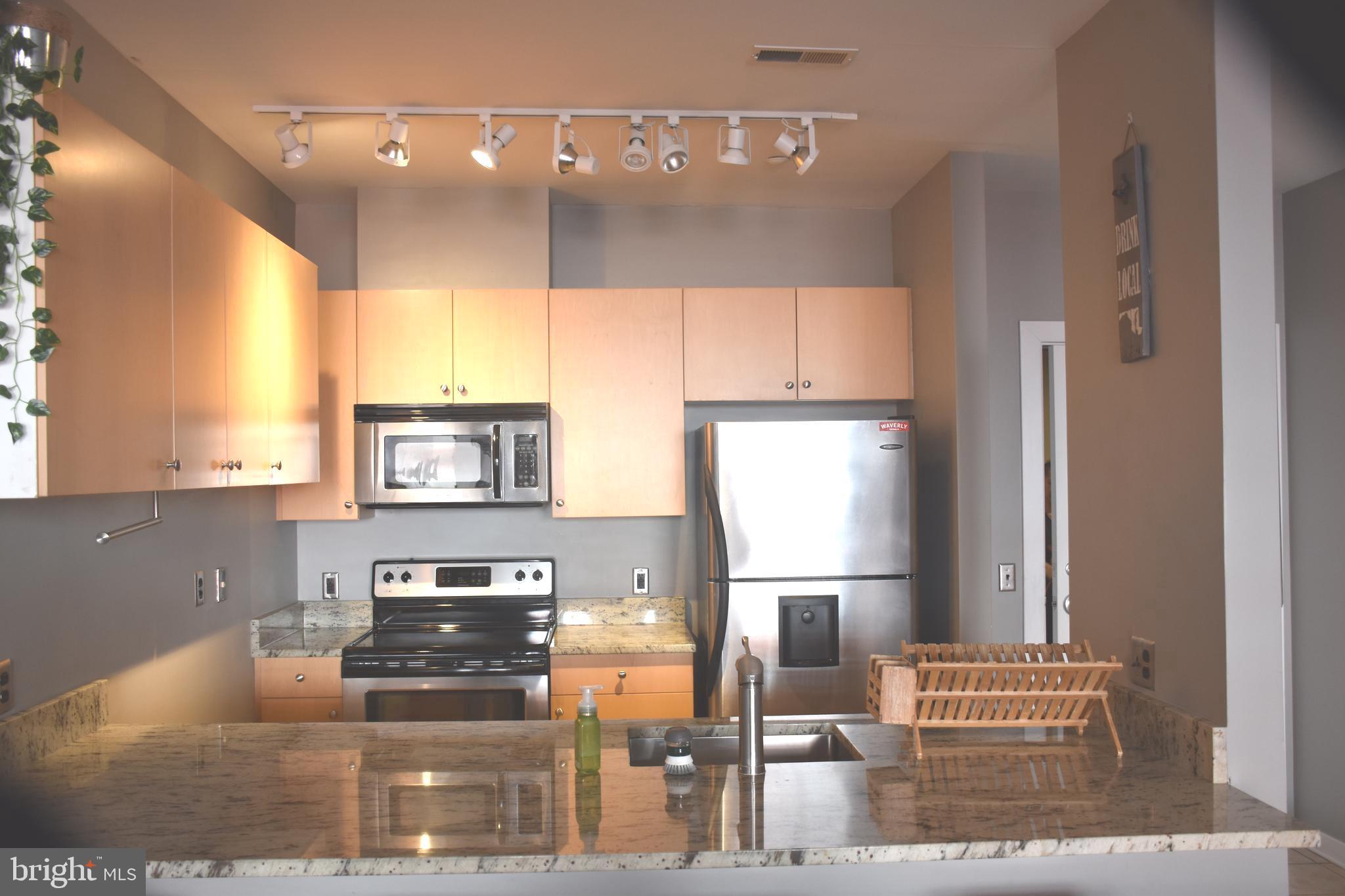 2007 Clipper Park Road, Unit 212 Baltimore, MD 21211 - Photo 9 of 33 a kitchen with stainless steel appliances granite countertop a refrigerator and a stove